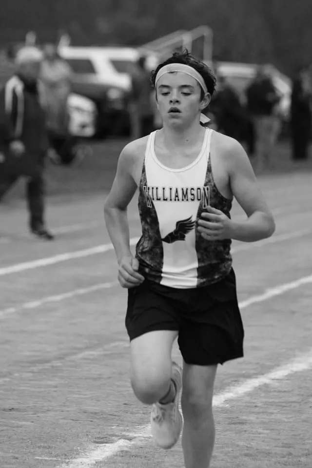 Cole mid-race in a Williamson cross country singlet, in black and white