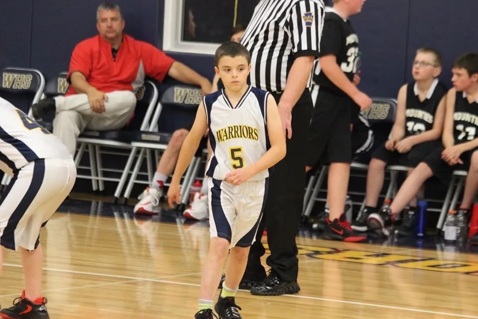 Cole in a youth Warriors basketball uniform during a game